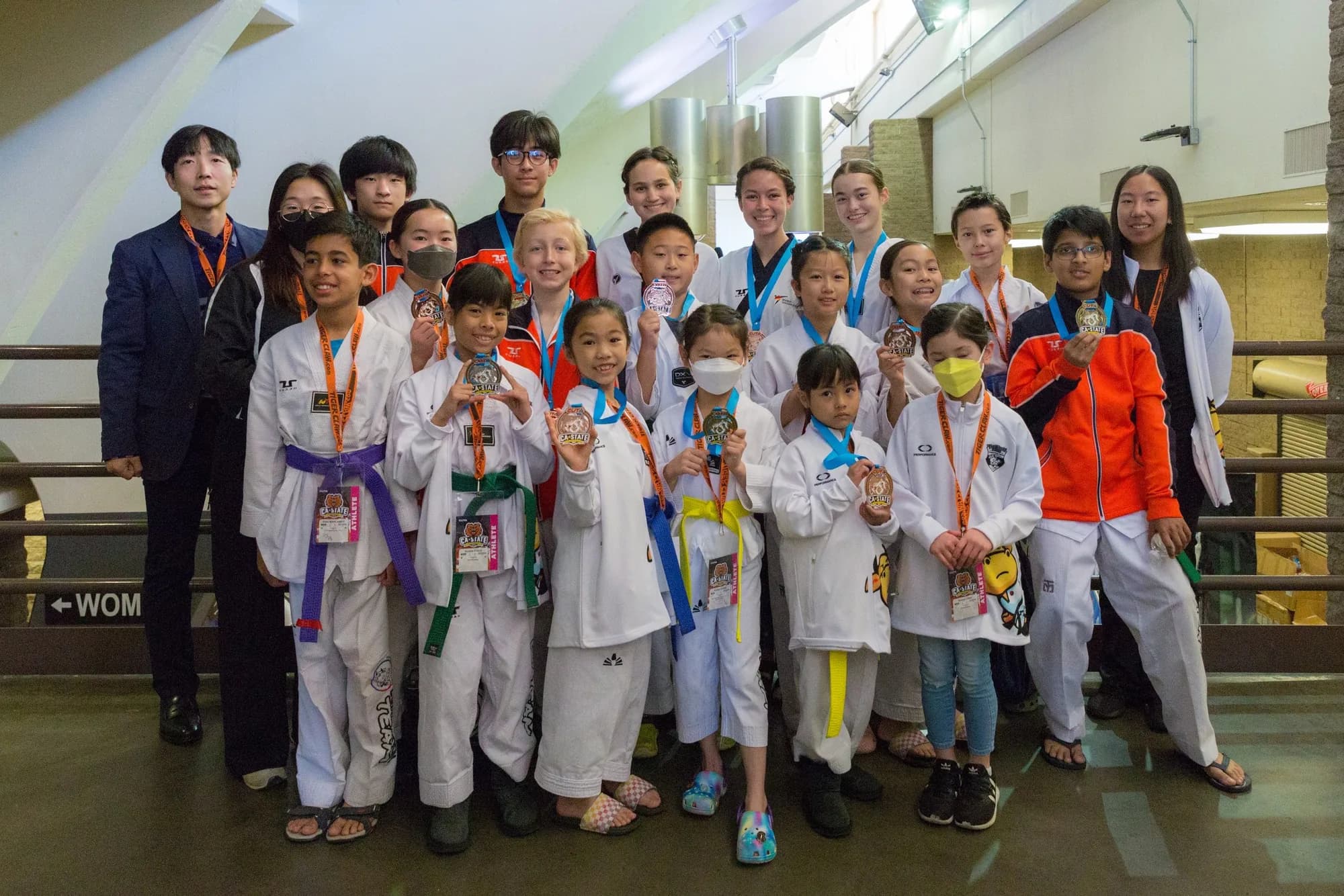 Un equipo numeroso de la escuela anterior del Maestro Lee con medallas del estado de California