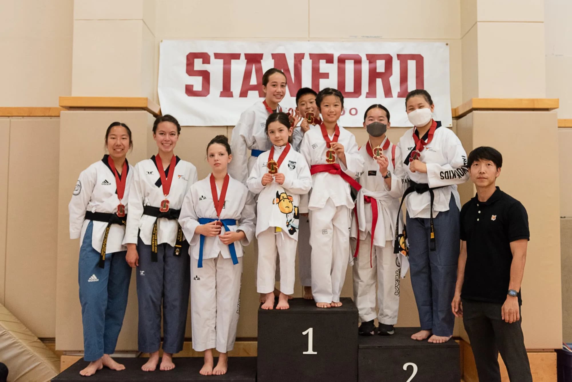 Estudiantes de la escuela anterior del Maestro Lee en el podio de un torneo de Taekwondo en Stanford